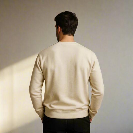 Man wearing a beige sweater from behind on a plain background