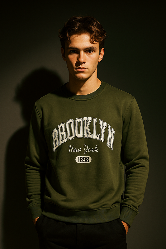 Man wearing a green sweatshirt with 'Brooklyn New York 1898' text against a dark background