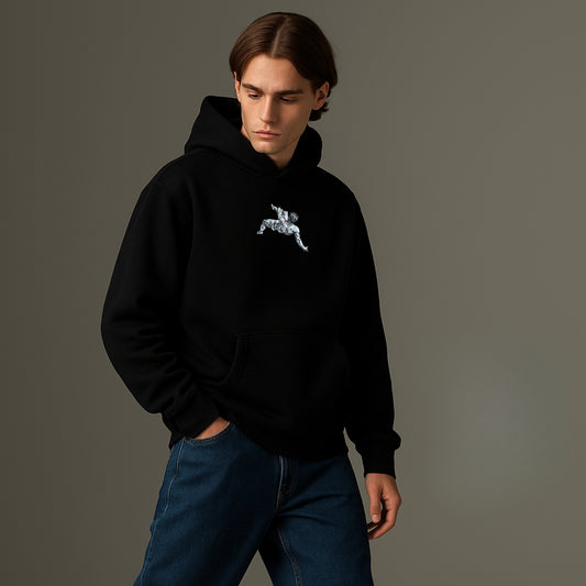 Person wearing a black hoodie with a white embroidery on a gray background