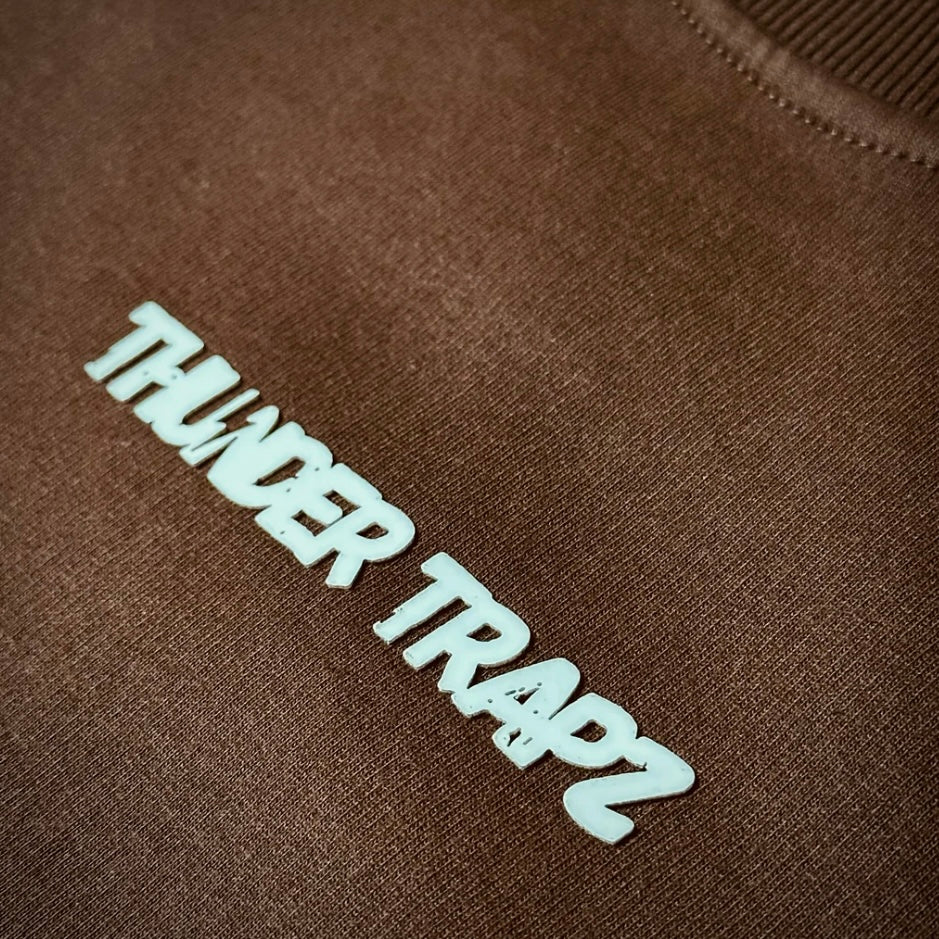 Brown sweatshirt with 'THUNDER TRAPZ' logo in white on a brown background